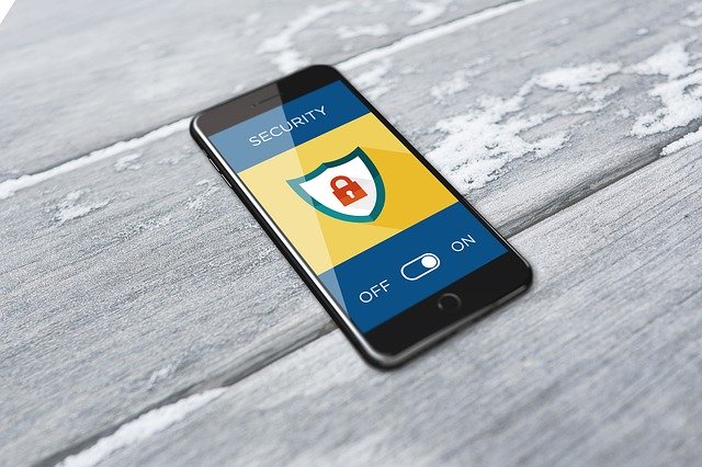 Ein Smartphone, auf dessen Bildschirm eine App mit dem Titel Security zu sehen ist. In der Mitte ist ein Logo mit einem Vorhängeschloss, unten am Bildschirm ist ein digitaler Schalter zwischen off und on.